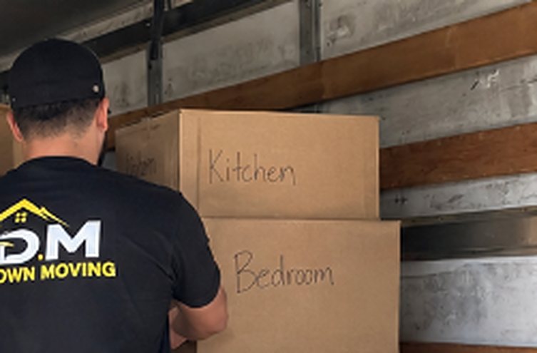 Boxes labeled Kitchen and Bedroom being packed